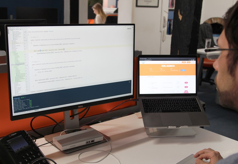 A developer working in the Cyber-Duck office on two screens.