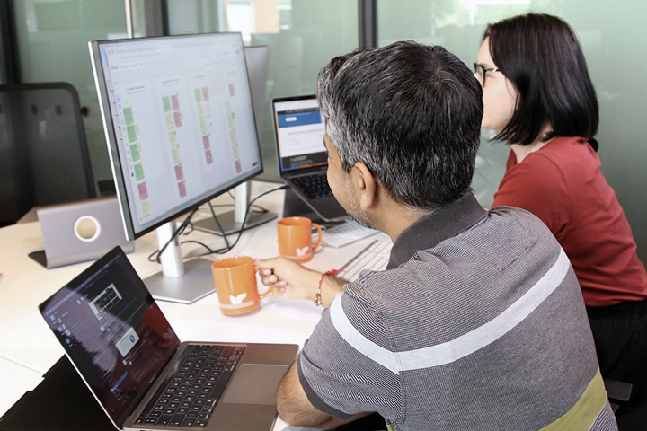 A developer and marketer working on their computers