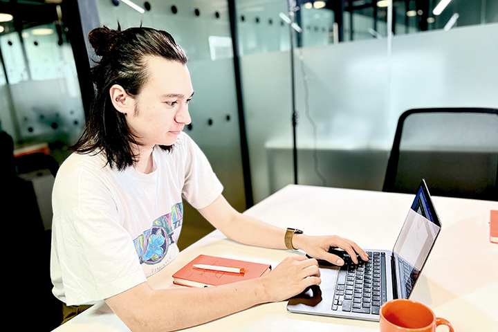 UX Designer working on his laptop in an office space