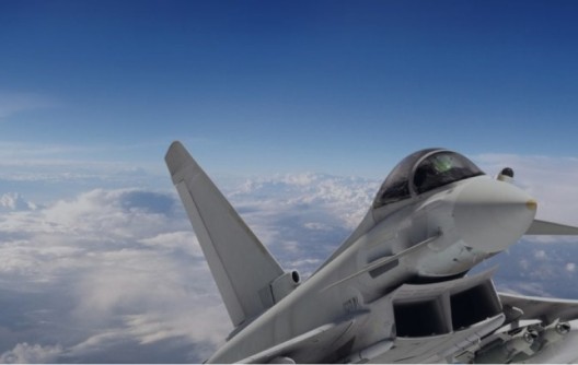 Fighter jet flying above clouds