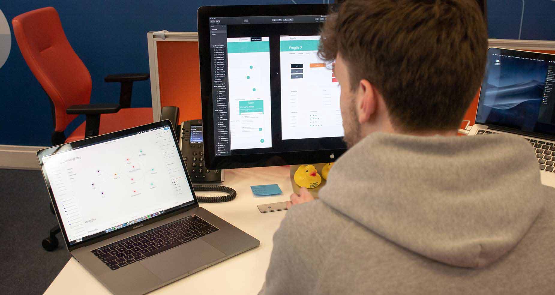Photo of a Cyber-Duck employee working on a health app visual design at his workstation
