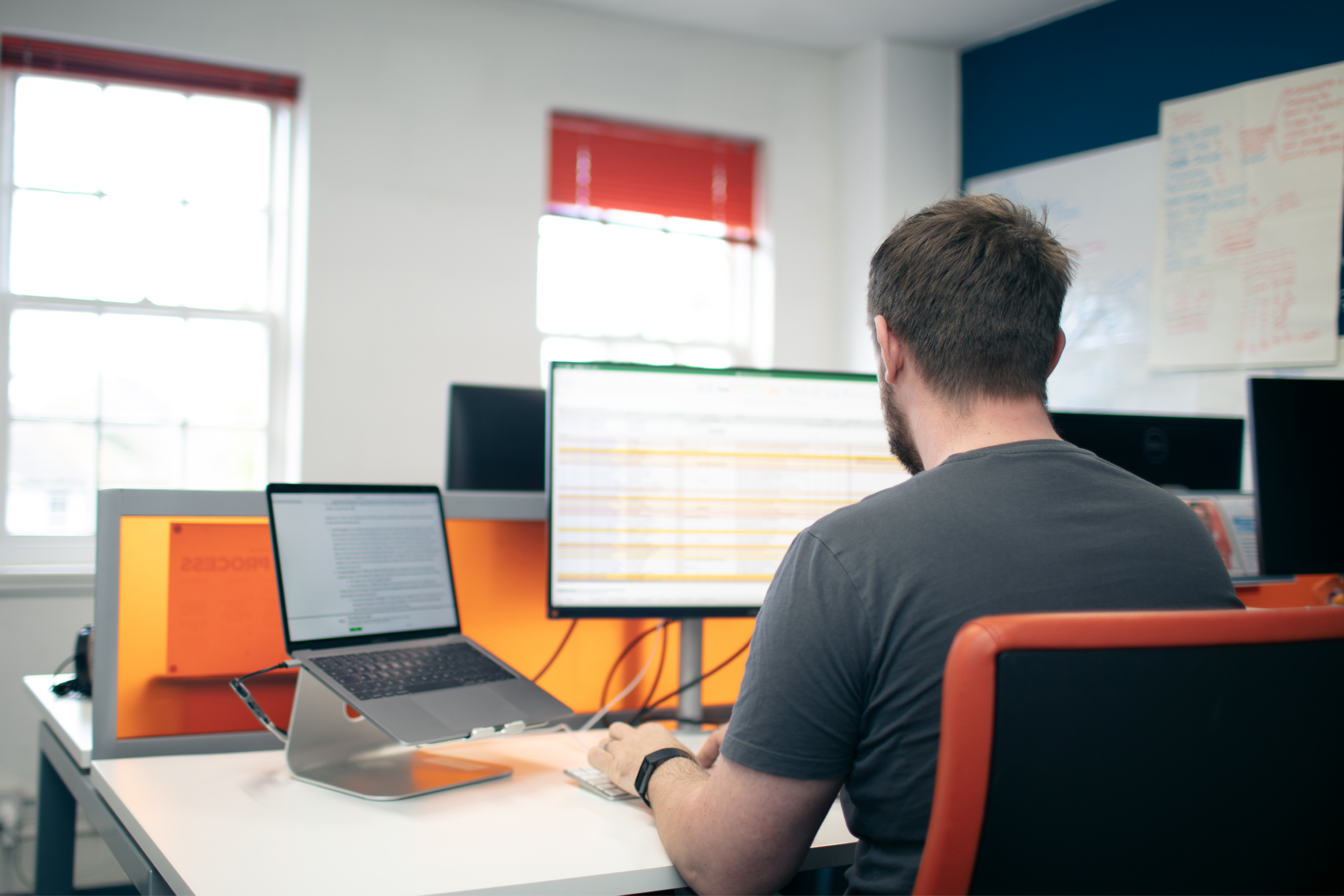 James, one of the UX team who worked on the College of Policing, sitting at his laptop working on their content strategy.