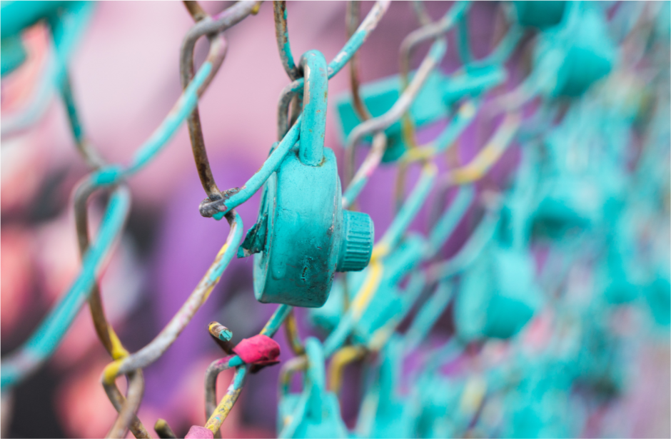 A green lock attached to a fence, representing the importance of data security.