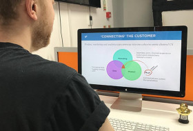 Jordan looks at a customer connection slide on a MacBook