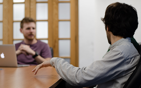 Photo of Cyber-Duck employees discussing at a conference table