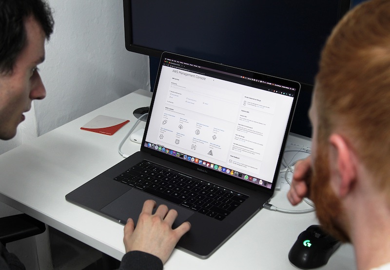 Developers working on Amazon Web Services on a laptop.