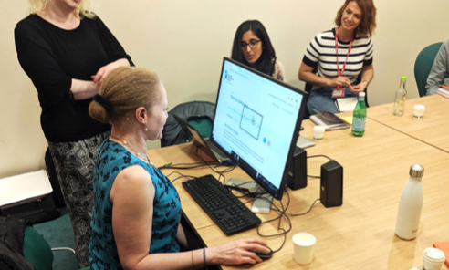 Two members of the design team observe a disabled user whilst she tests out an interface at the RNIB