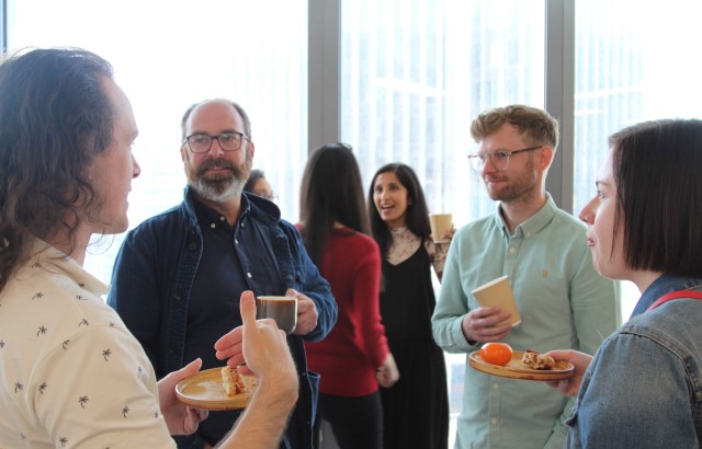 Photo of some of the creative team standing with party food and in discussion