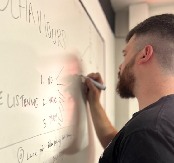 A member of the Cyber-Duck team mapping out ideas on a whiteboard.