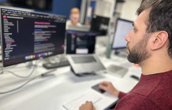 Photo of tech lead Tiago coding at this desk in the Cyber-Duck office